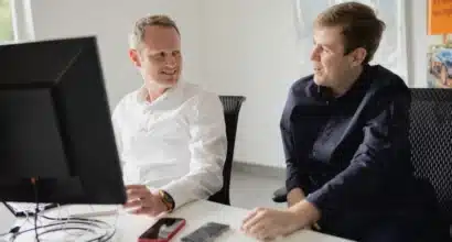 Équipe XS Groupe réunie autour d'un collaborateur qui écrit sur un tableau blanc